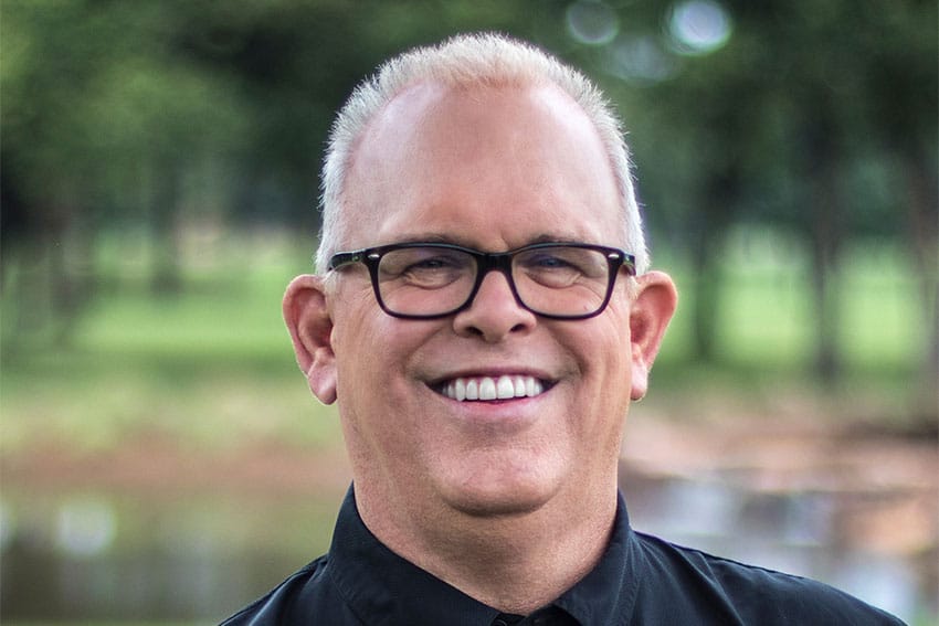 man smiles confidentially while enjoying the outdoors