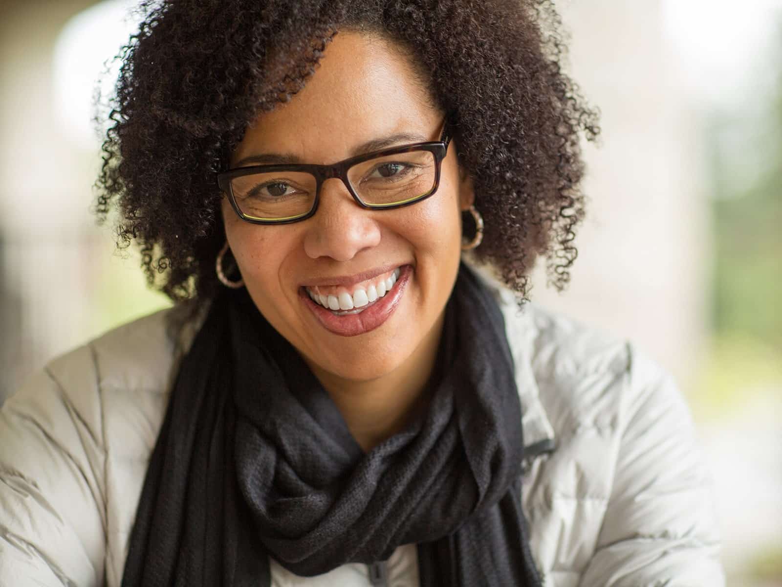 Woman with glasses smiling leaning in