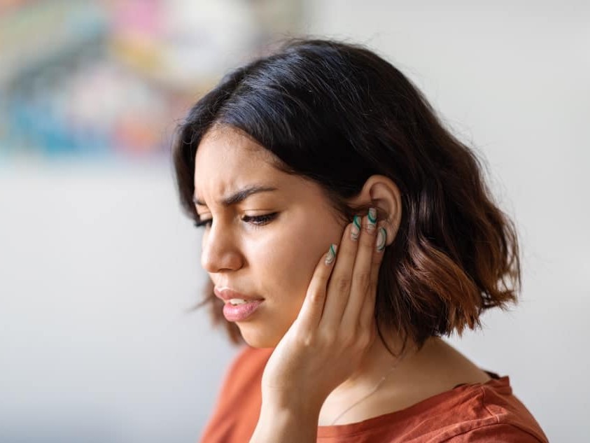woman grabbing jaw in pain