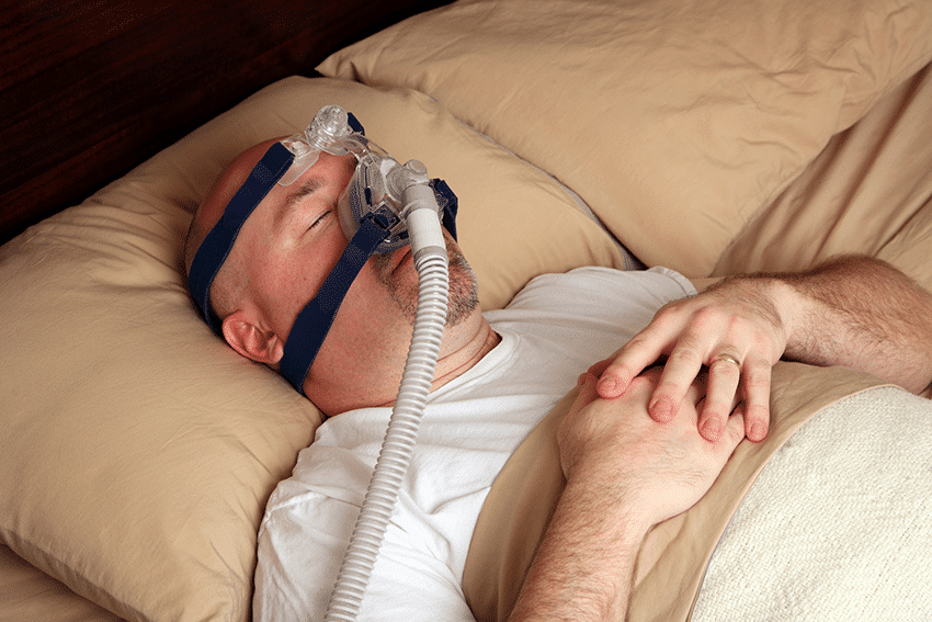 man sleeping with CPAP mask
